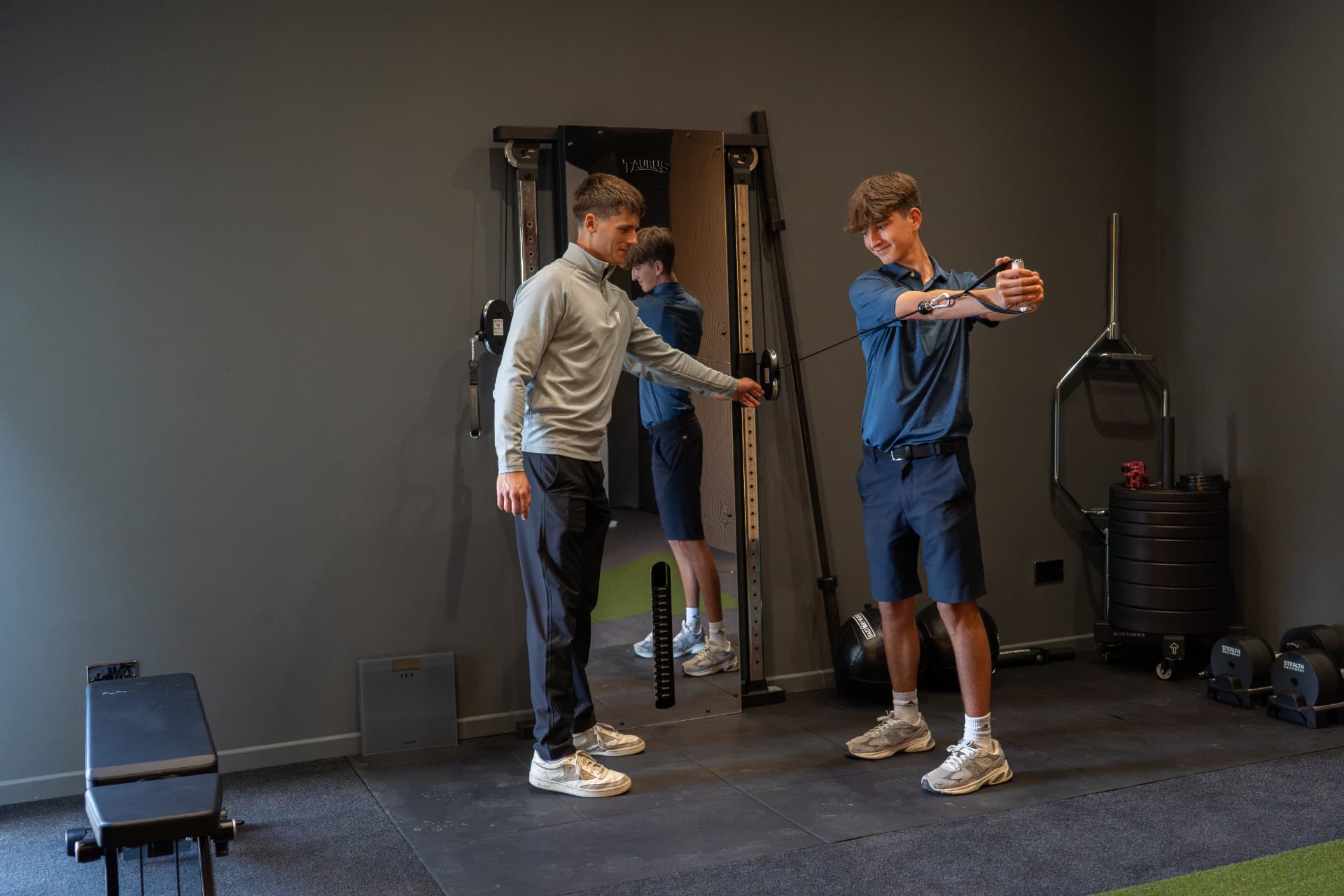 Coach supervising a cable rotation exercise in the COTT Coaching studio at Lewes Golf Club